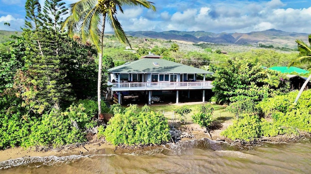 rear view of house featuring a water and mountain view