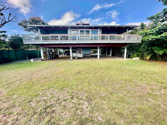 rear view of house featuring a wooden deck and a yard