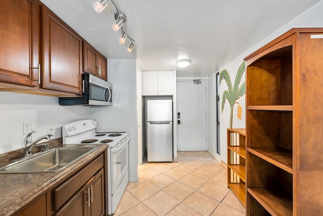 kitchen with sink, light tile patterned floors, and appliances with stainless steel finishes