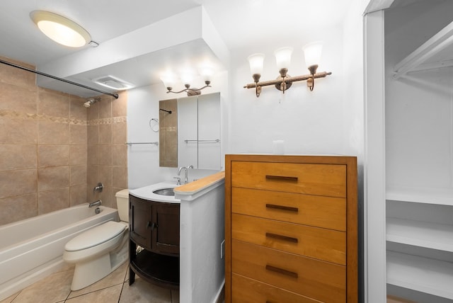 full bathroom featuring tile patterned flooring, toilet, tiled shower / bath combo, and vanity