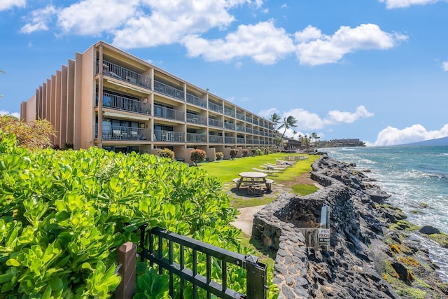 view of building exterior featuring a water view and a fire pit