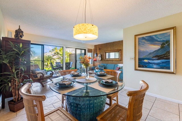 tiled dining area with a textured ceiling and a wealth of natural light