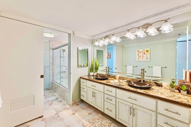 bathroom featuring vanity, enclosed tub / shower combo, and crown molding