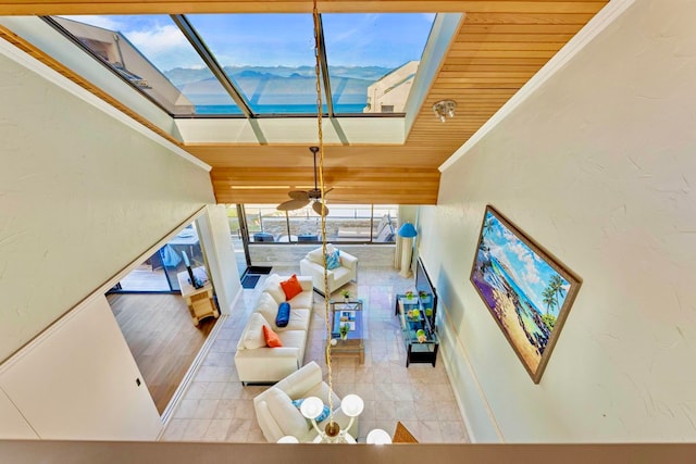 living room with a mountain view, wood ceiling, and ornamental molding