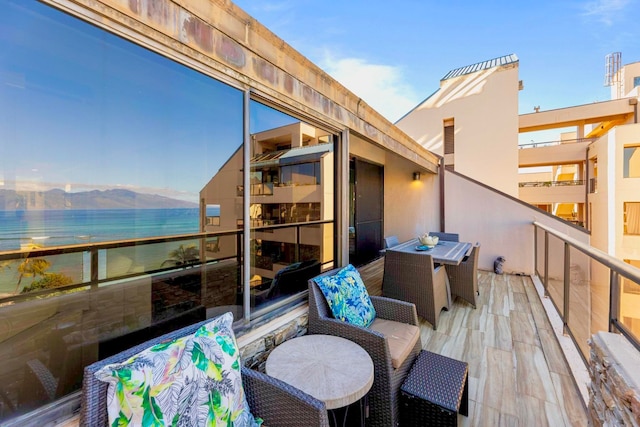 balcony featuring a water and mountain view