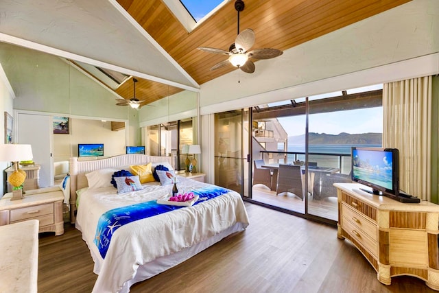 bedroom featuring access to exterior, ceiling fan, a skylight, dark hardwood / wood-style floors, and wood ceiling