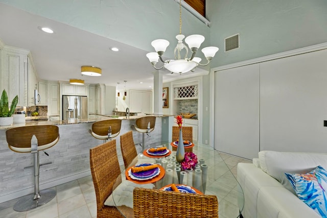 tiled dining space featuring sink and an inviting chandelier