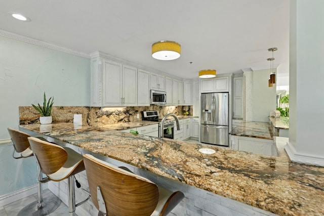 kitchen with white cabinetry, kitchen peninsula, stone countertops, a breakfast bar area, and appliances with stainless steel finishes