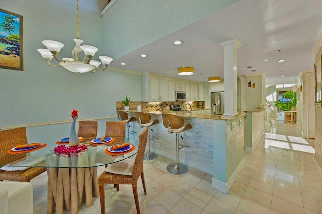 dining area with a notable chandelier, sink, light tile patterned floors, and crown molding