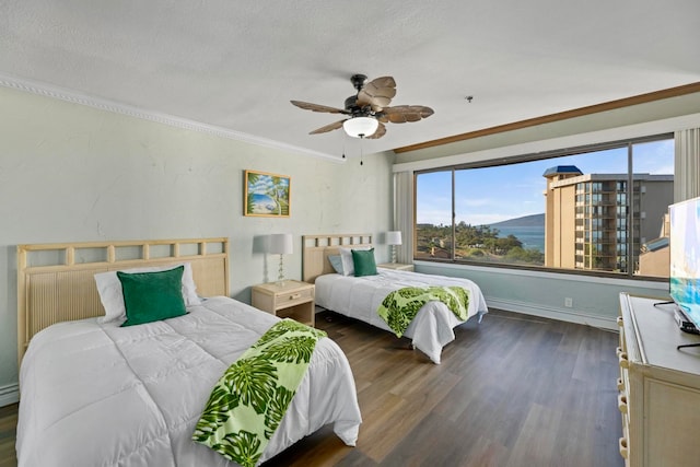 bedroom with ceiling fan, dark hardwood / wood-style flooring, ornamental molding, and a textured ceiling