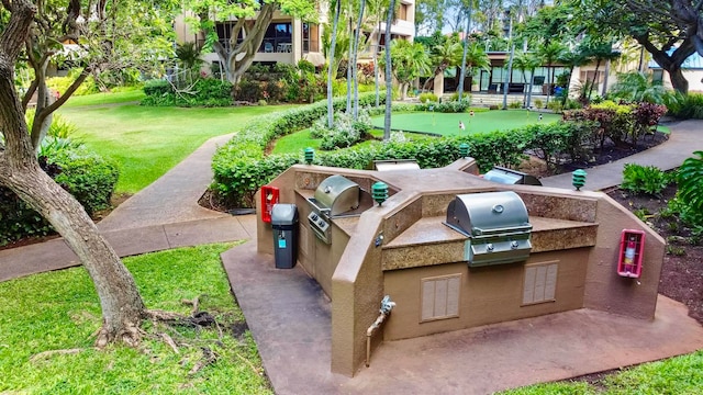 view of home's community with area for grilling and a yard