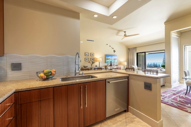 kitchen featuring dishwasher, sink, decorative backsplash, light tile patterned floors, and kitchen peninsula