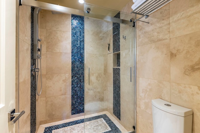 bathroom with toilet and an enclosed shower