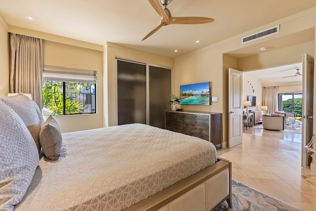 bedroom featuring light tile patterned floors, crown molding, a closet, and ceiling fan