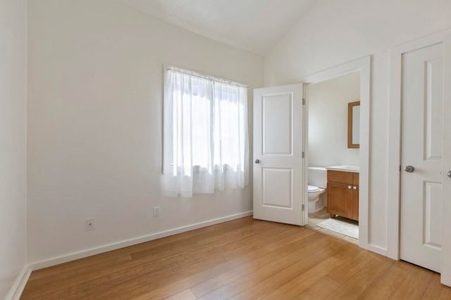 534 Kaikoo Pl, Wailuku, HI 96793 - unfurnished bedroom featuring light wood-style floors, vaulted ceiling, ensuite bath, and baseboards