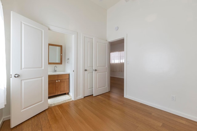 534 Kaikoo Pl, Wailuku, HI 96793 - unfurnished bedroom with light wood finished floors, connected bathroom, baseboards, and a high ceiling