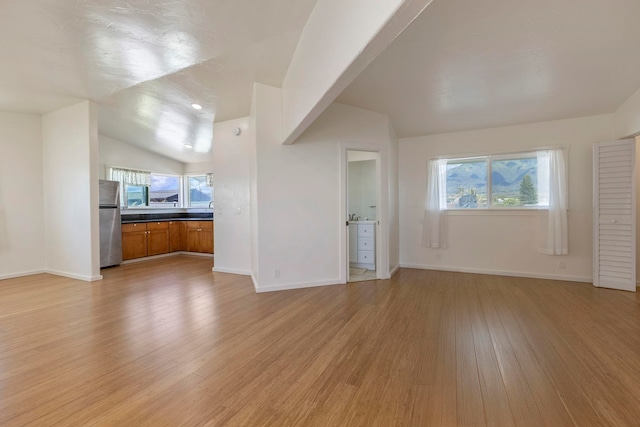 534 Kaikoo Pl, Wailuku, HI 96793 - unfurnished living room with vaulted ceiling, light wood-type flooring, healthy amount of natural light, and baseboards