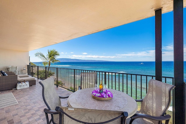 balcony with a water view and an outdoor hangout area