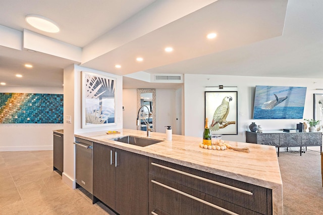 kitchen with light tile patterned flooring, dishwasher, light stone counters, dark brown cabinetry, and sink