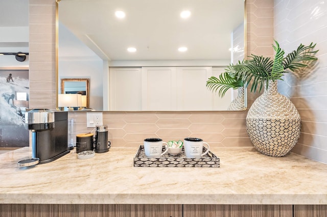 interior space featuring light stone countertops, white cabinets, and tasteful backsplash