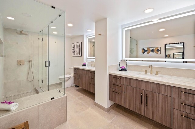 bathroom with toilet, tile patterned floors, a shower with shower door, and vanity