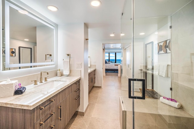 bathroom featuring tile patterned flooring, a shower with shower door, and vanity