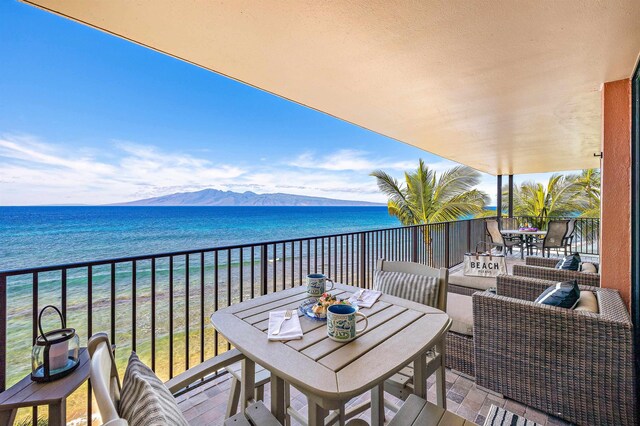 balcony with a water and mountain view and a view of the beach