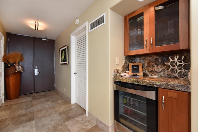 interior space featuring dark stone countertops, backsplash, and beverage cooler