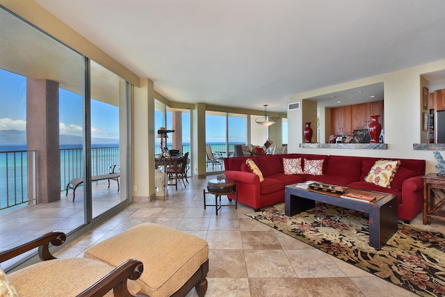 living room with a water view, a wall of windows, and a wealth of natural light