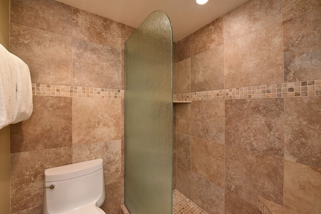 bathroom with tiled shower and toilet