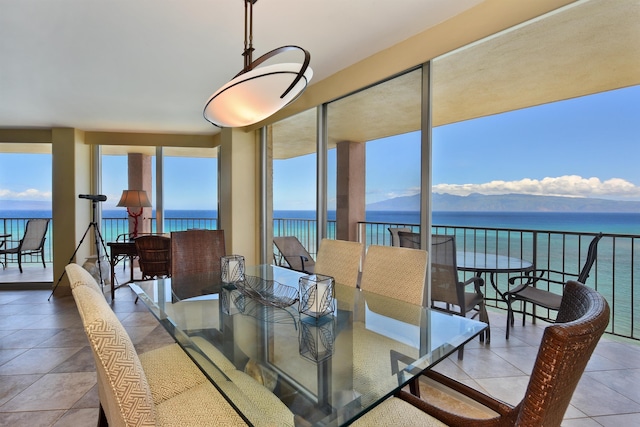 dining area featuring a water view and light tile patterned floors