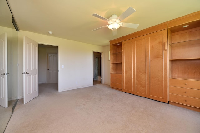 unfurnished bedroom with light carpet, a ceiling fan, and baseboards