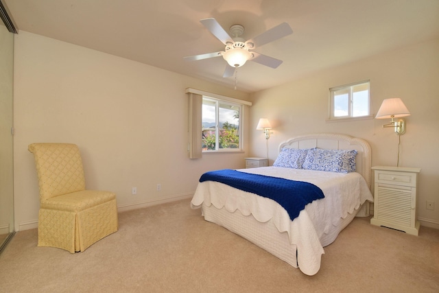 carpeted bedroom with ceiling fan, multiple windows, and baseboards