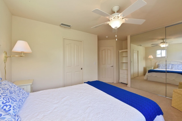 bedroom with light colored carpet, a closet, visible vents, and ceiling fan