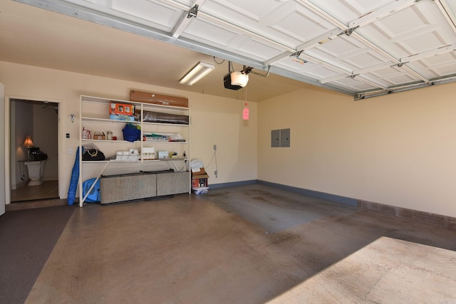 garage with electric panel, baseboards, and a garage door opener