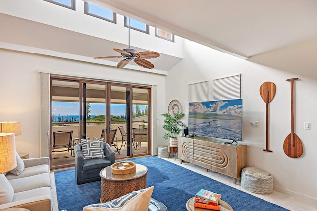 carpeted living room with ceiling fan and a towering ceiling