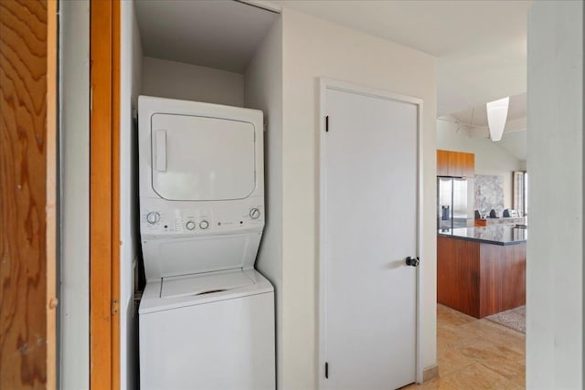 clothes washing area with laundry area and stacked washer and dryer