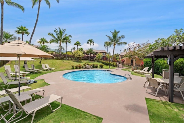 community pool featuring a lawn, fence, and a patio
