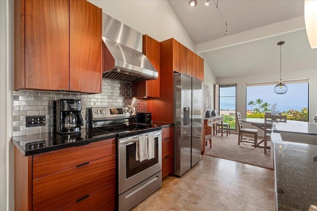 kitchen with decorative backsplash, brown cabinetry, appliances with stainless steel finishes, lofted ceiling, and wall chimney exhaust hood