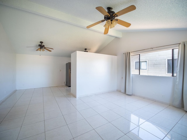 empty room featuring light tile patterned floors, ceiling fan, lofted ceiling with beams, and a textured ceiling