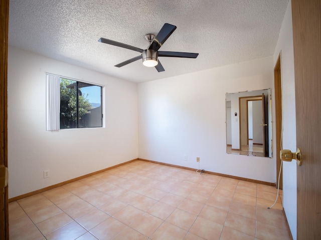 tiled spare room with a textured ceiling and ceiling fan