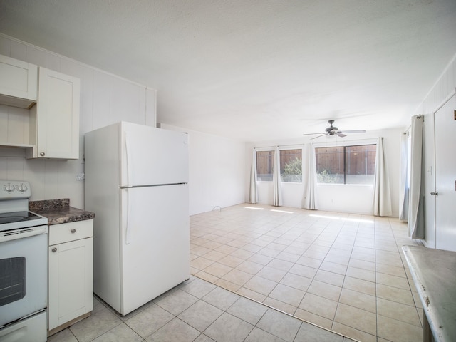 kitchen featuring white appliances, ceiling fan, light tile patterned floors, and white cabinetry