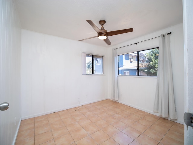 empty room with ceiling fan and light tile patterned floors