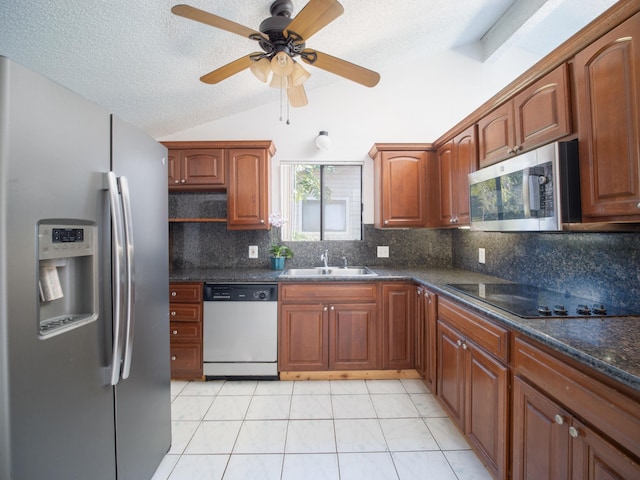 kitchen featuring light tile patterned floors, lofted ceiling, appliances with stainless steel finishes, ceiling fan, and sink