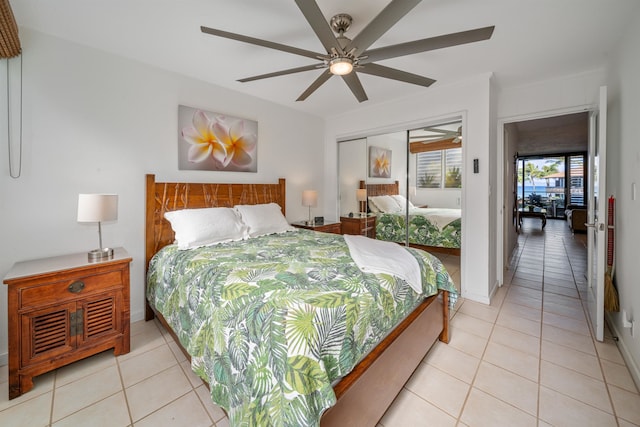 tiled bedroom with ceiling fan and a closet