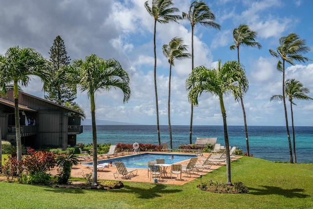 view of swimming pool with a water view, a patio, and a lawn