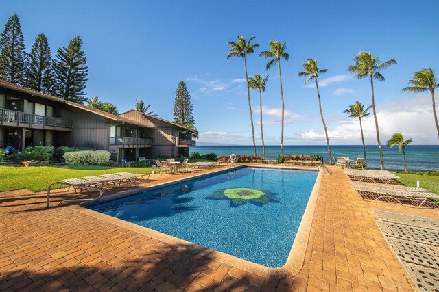 view of swimming pool featuring a patio area and a water view