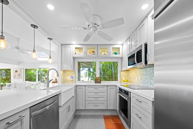 kitchen featuring light tile floors, stainless steel appliances, pendant lighting, ceiling fan, and sink