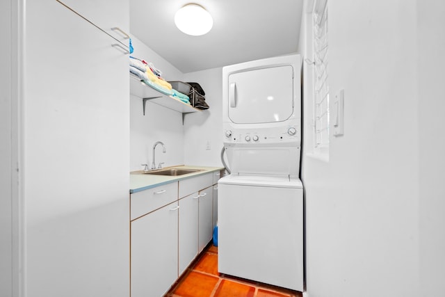 laundry room featuring cabinets, stacked washer / drying machine, sink, and light tile flooring