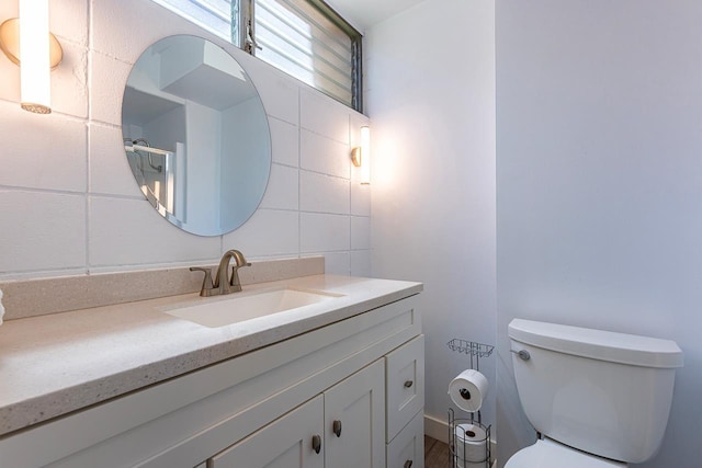 bathroom with backsplash, vanity, and toilet